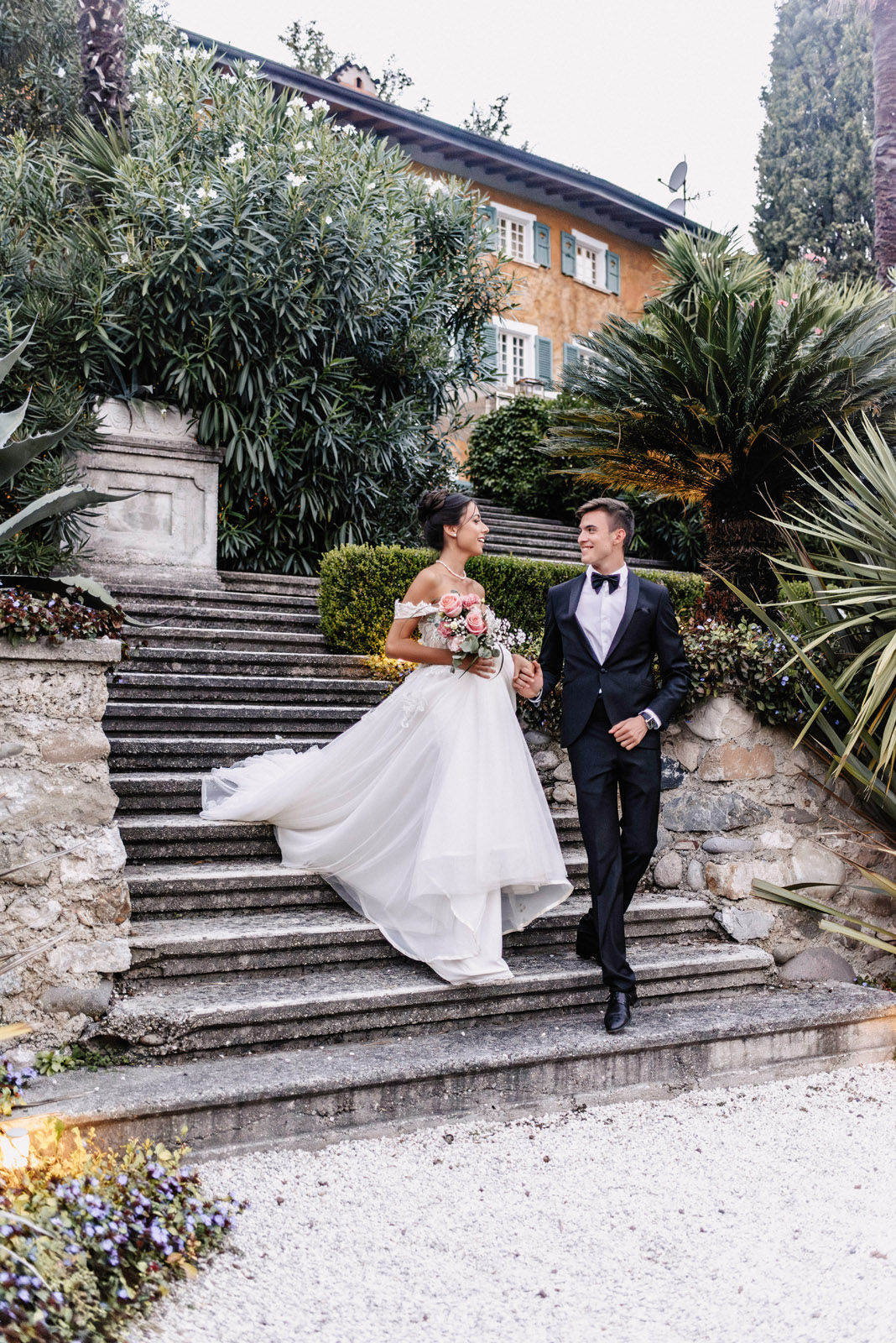 Couple descending the stone stairs of an Italian villa hand in hand