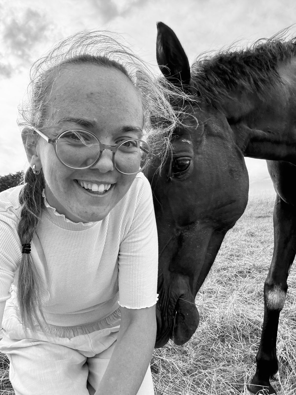 Greta with one of her horses, forehead to forehead
