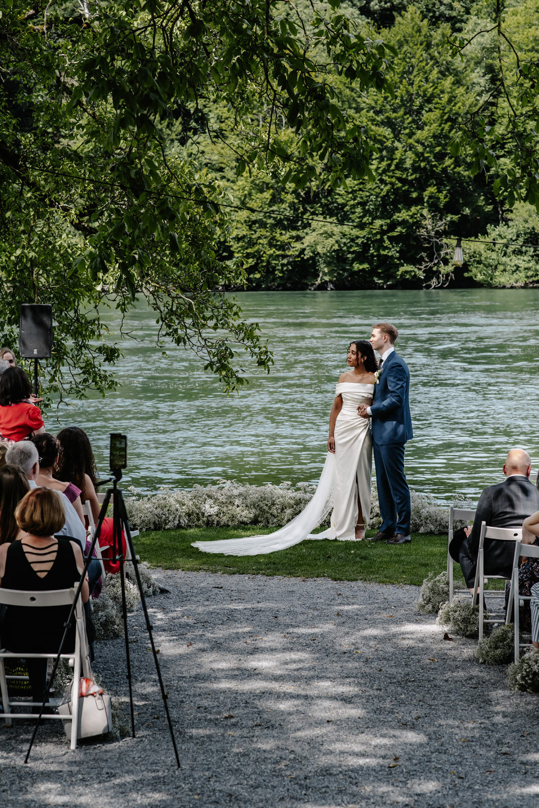 Elisa and Dominik at their open-air vows on the bank of the Rhine, seen over the guests’ shoulders