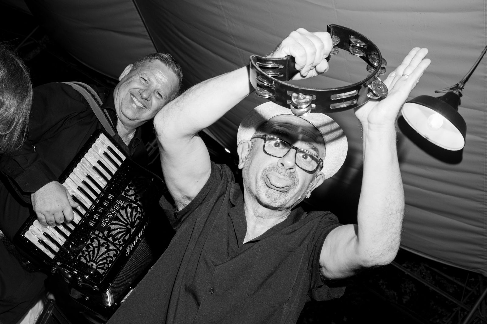 A guest with a tambourine and the band in full swing at a Tuscan wedding party